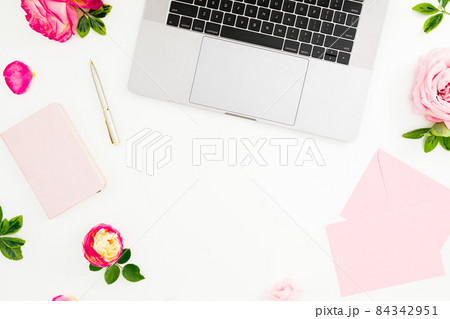Laptop with roses, pen, envelope and copy space on white background. Flat lay Laptop with roses, pen, envelope and copy space on white background. Flat lay 84342951