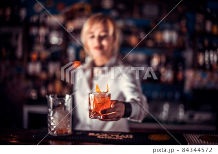 Girl barman formulates a cocktail in the taproom 84344572