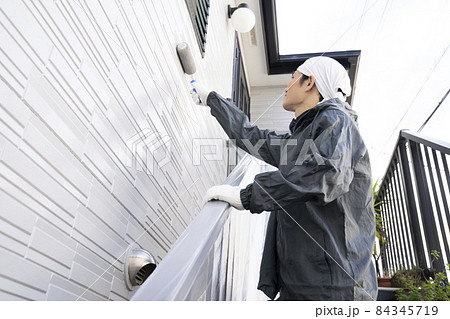 ローラーで戸建て住宅の外壁を塗る塗装職人 84345719