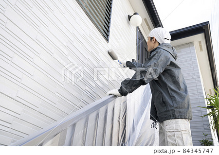 ローラーで戸建て住宅の外壁を塗る塗装職人 84345747