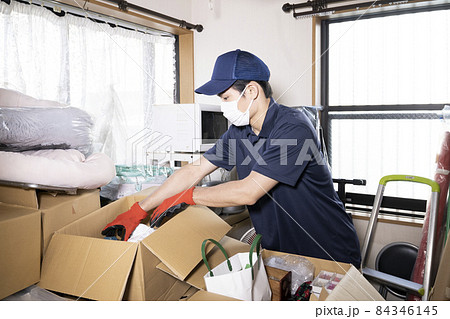 散らかった部屋の片付けをする男性作業員 散らかった部屋の片付けをする男性作業員 84346145