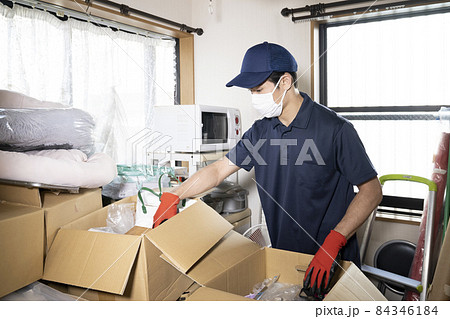 散らかった部屋の片付けをする男性作業員 散らかった部屋の片付けをする男性作業員 84346184