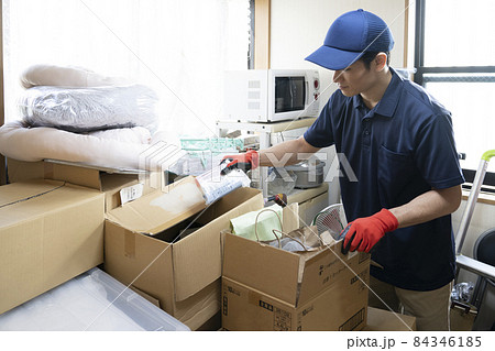 散らかった部屋の片付けをする男性作業員 散らかった部屋の片付けをする男性作業員 84346185