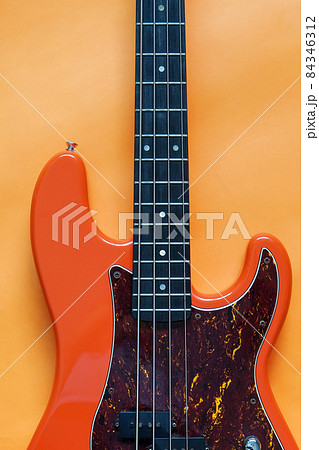 orange electric bass guitar on orange background  84346312