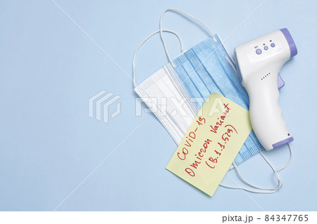 Omicron variant text on piece of paper. New covid variant from South Africa. Vaccine vial, syringe and face mask on bright colored background. New South African omicron variant of SARS-CoV-2 84347765