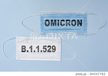 Female doctor holds a face mask with - Omicron variant text on it. Covid-19 new variant - Omicron. Omicron variant of coronavirus. SARS-CoV-2 variant of concern Female doctor holds a face mask with - Omicron variant text on it. Covid-19 new variant - Omicron. Omicron variant of coronavirus. SARS-CoV-2 variant of concern 84347783