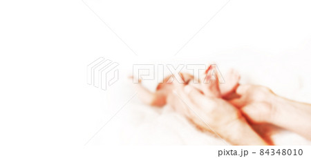 mom holds the legs of her newborn baby. blurred image for the advertising text. mom holds the legs of her newborn baby. blurred image for the advertising text. 84348010