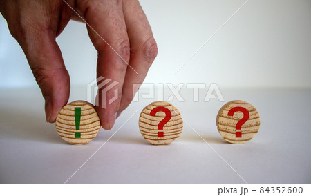 Male hand putting circle with exclamation mark near circles with question marks. Beautiful white background. Business and education concept. Copy space. Male hand putting circle with exclamation mark near circles with question marks. Beautiful white background. Business and education concept. Copy space. 84352600