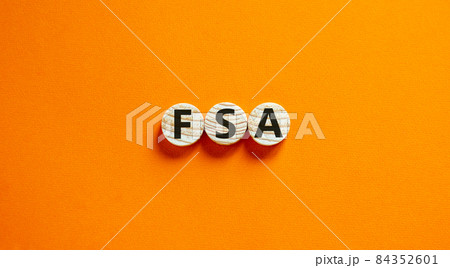 Concept words 'FSA, flexible spending account' on wooden circles on a beautiful orange background. Copy space, business concept. Concept words 'FSA, flexible spending account' on wooden circles on a beautiful orange background. Copy space, business concept. 84352601
