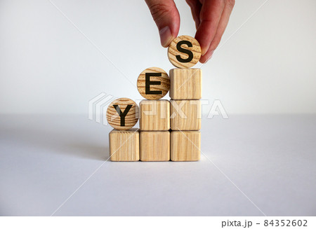 Business concept growth success process. Male hand. Wood blocks and circles with word 'yes' stacking as step stair on white background, copy space. Business concept growth success process. Male hand. Wood blocks and circles with word 'yes' stacking as step stair on white background, copy space. 84352602