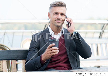 Handsome businessman talk on mobile phone drinking takeaway coffe cup, drink Handsome businessman talk on mobile phone drinking takeaway coffe cup, drink 84353403
