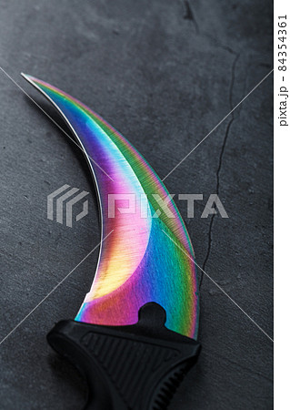 A dagger with a steel blade with a gradient color on a black background. 84354361