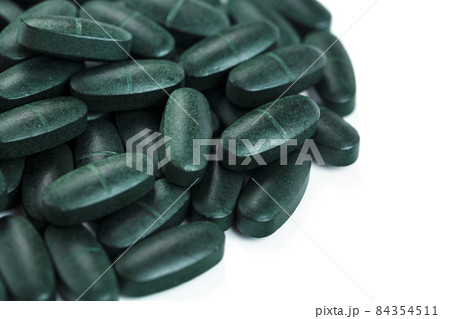 Pills with Vitamins and spirulina on a white background. 84354511