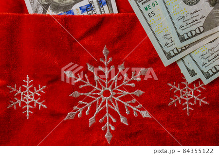 Christmas decoration Santa red bag US dollar bills on red background Christmas decoration Santa red bag US dollar bills on red background 84355122