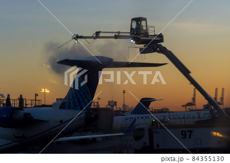 Flight safety with airport staff preparing airplane for the flight deicing the wing of the aircraft at winter from outside the airplane Flight safety with airport staff preparing airplane for the flight deicing the wing of the aircraft at winter from outside the airplane 84355130