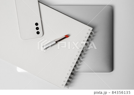 Minimalist and clean Female workspace with laptop, smart phone , notebook, and red lipstick 84356135