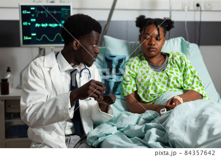 African american practitioner doctor holding lungs radiography explaining healthcare treatment 84357642