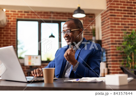 Entrepreneur clenching fist to celebrate business achievement in startup office 84357644