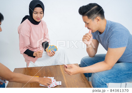 Woman, young man and a friend playing cards together 84361370