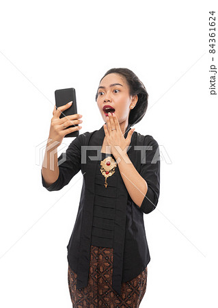 beautiful woman with kebaya clothes schocked while looking phone 84361624