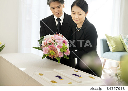 棺に花束を供えるミドルの男女　家族葬　自宅葬イメージ 84367018