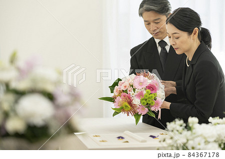 棺に花束を供えるミドルの男女 棺に花束を供えるミドルの男女 84367178