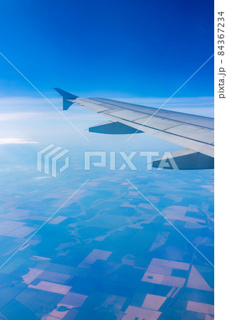View from the airplane window at a beautiful blee clear sky and the airplane wing View from the airplane window at a beautiful blee clear sky and the airplane wing 84367234