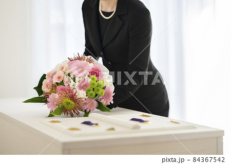 喪服を着た女性が供える棺上花束　エンディングブーケ　シンプルなお葬式　イメージ 84367542