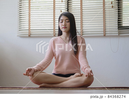 Morning yoga with an Asian woman, sitting in Easy position, Sukhasana posture, and meditating online. Morning yoga with an Asian woman, sitting in Easy position, Sukhasana posture, and meditating online. 84368274