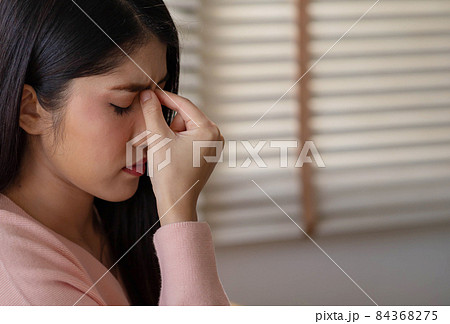 Asian woman massaging nose bridge temples. Stressed unhealthy millennial mixed race girl feeling tired suffering from migraine, panic attack. Asian woman massaging nose bridge temples. Stressed unhealthy millennial mixed race girl feeling tired suffering from migraine, panic attack. 84368275