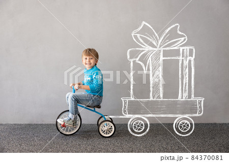 Happy child riding bike. Christmas holiday concept 84370081