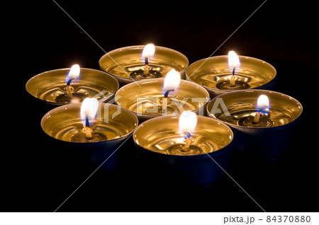 Small candles burning with black background. Candles with liquid wax. Small candles burning with black background. Candles with liquid wax. 84370880