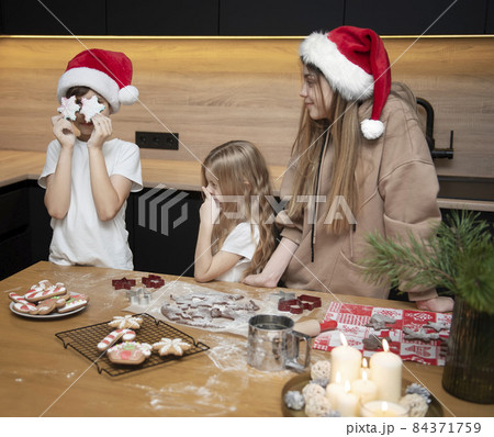 Children are preparing gingerbread in the kitchen Children are preparing gingerbread in the kitchen 84371759