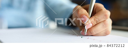 Woman hand writing with silver ballpoint pen in notebook closeup 84372212