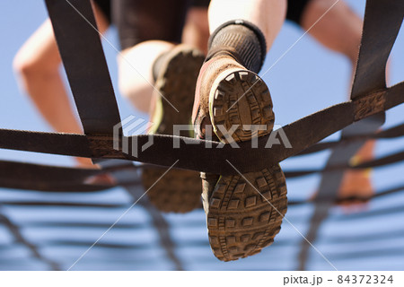 Athlete climbs the net, climbing net in an obstacle course. Look from below 84372324