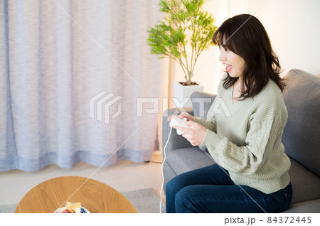 夜の自宅でゲームに寝厨する女性 84372445
