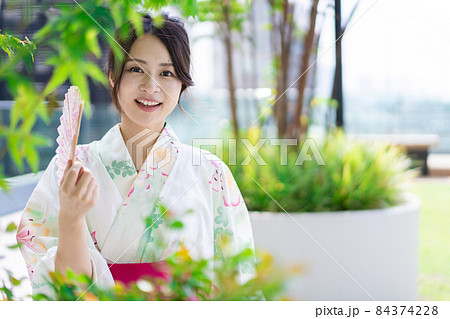 浴衣を着て街を歩く若い女性 84374228