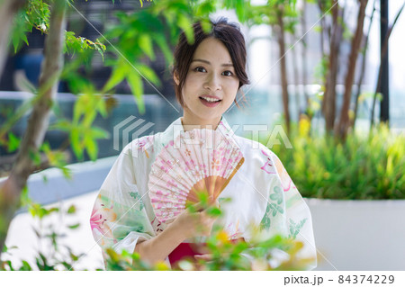浴衣を着て街を歩く若い女性 84374229