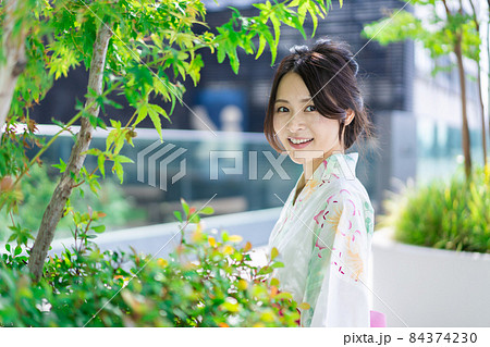 浴衣を着て街を歩く若い女性 84374230