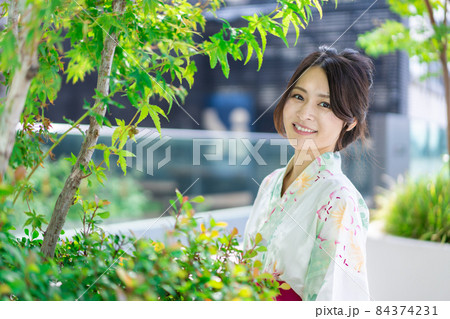 浴衣を着て街を歩く若い女性 84374231