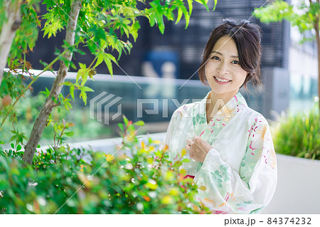 浴衣を着て街を歩く若い女性 84374232