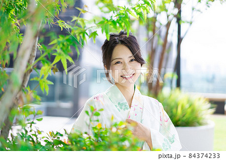 浴衣を着て街を歩く若い女性 84374233