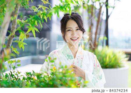 浴衣を着て街を歩く若い女性 84374234