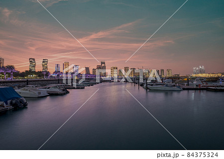 Lusail marina in Lusail city , Qatar at sunset with Yachts and boats ,Lusail skyline and clouds in the sky in  background 84375324