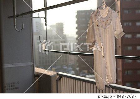 朝日を浴びる干したベビー服 84377637