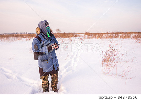 Caucasian Man in the blue jacket with a remote controller Caucasian Man in the blue jacket with a remote controller 84378556