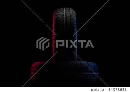 tires with a tread for winter driving on a black background with an image of red-blue illumination tires with a tread for winter driving on a black background with an image of red-blue illumination 84378631