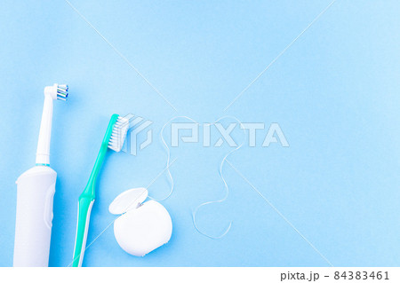 Manual toothbrush, electric toothbrush and dental floss, blue background, copy space, horizontal 84383461