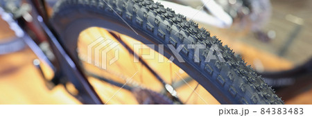 Reliable tire with quality tread on bicycle wheel closeup 84383483