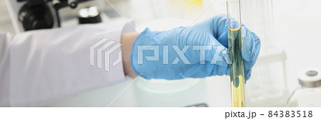 Scientist conducts laboratory tests of transparent liquid in test tube 84383518